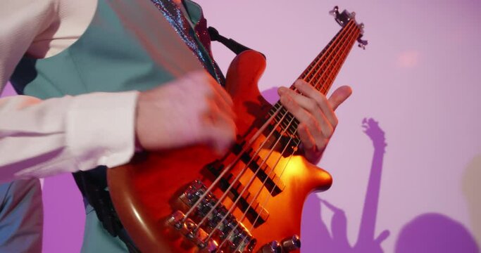Hands of man professional talented musician bass guitarist virtuoso masterly playing electric bass guitar in band. 