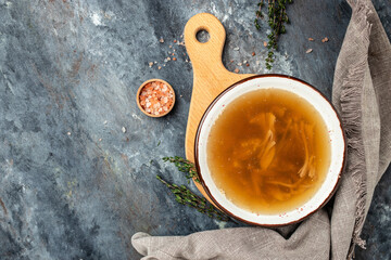 Bone meat chicken broth in a bowl on a dark background, banner, menu, recipe place for text, top view