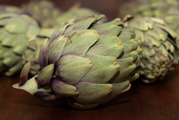 Obraz premium Close-up of artichokes lying on a wooden table.