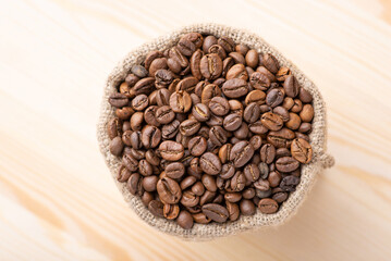 Dark roasted coffee beans in linen sack. Fresh aromatic coffee grain