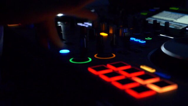 Close up hands deejay presses mixer button. Mixing music. Slow motion 