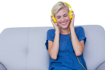 Cheerful woman listening music on sofa