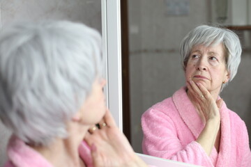 Profile of senior woman thinking with her own reflection 