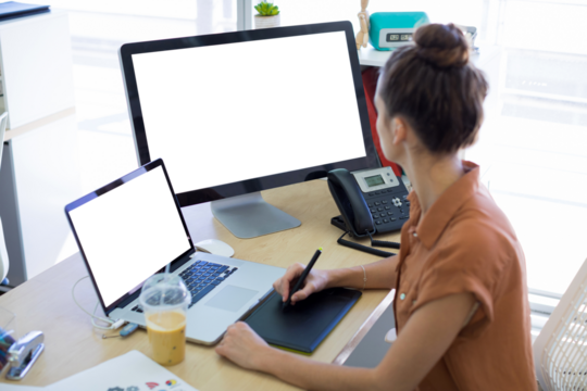 Side view of businesswoman working over graphic tablet at desk