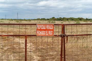 Portón de acceso a una finca con un letrero que prohíbe el acceso a una propiedad privada. Imagen...