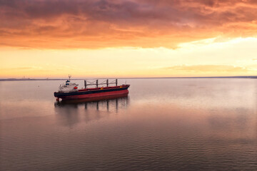 Fototapeta na wymiar Cargo ship in the open sea at the beautiful sunset. Aerial top view.Shipping. Grain export