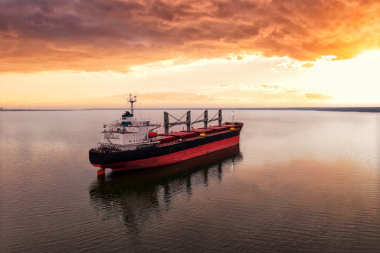 Cargo ship in the open sea at the beautiful sunset. Aerial top view.Shipping. Grain export