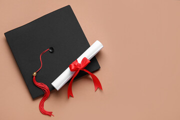 Diploma with red ribbon and graduation hat on brown background