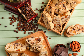 Composition with tasty biscotti cookies, almonds, chocolate and coffee beans on color wooden background