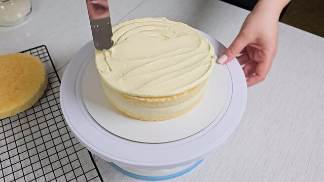 unrecognizable pastry chef preparing a layered frosted cake