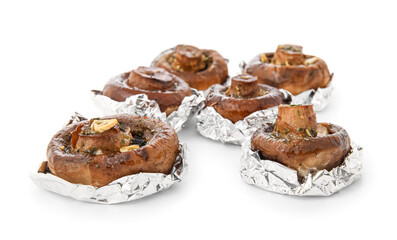 Tasty baked mushrooms in aluminium foil on white background