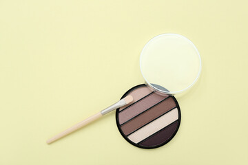 Eyeshadows with brush on yellow background