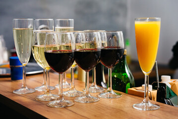 Glasses of red and white wine with orange juice on bar counter. Refreshments at the event.