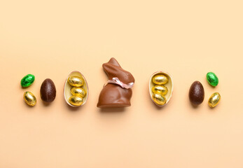 Chocolate bunny and Easter eggs on beige background