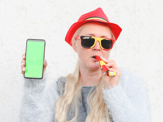 Caucasian woman in a hat with a Belgian flag, a pipe and with a mobile phone