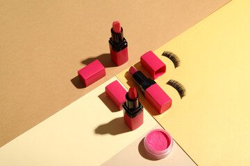 Lipsticks with false eyelashes on color background