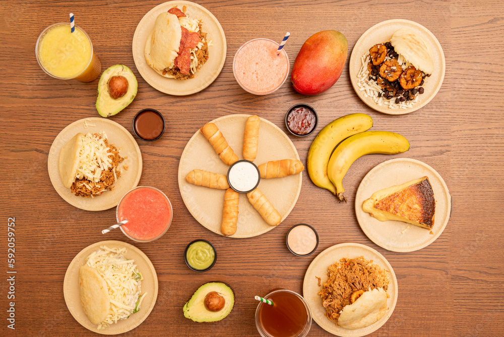 Wall mural set of venezuelan fast food dishes with many assorted arepas on a wooden table - Wall murals