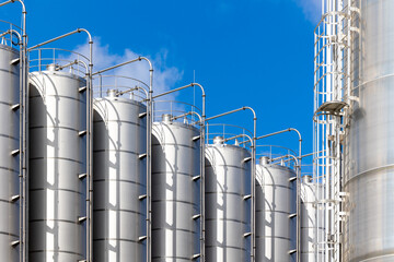 Stainless steel silos against the blue sky. Warehouses for storage of plastics and bulk grains. © Fotoforce