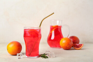 Glass of tasty blood orange lemonade on light background