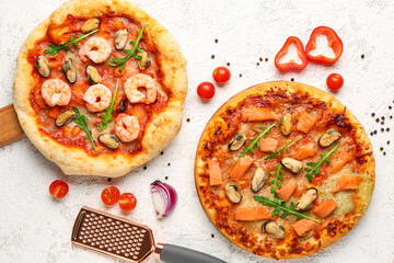 Tasty seafood pizzas on light background