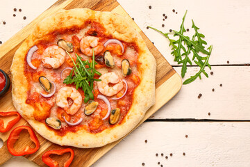 Board with tasty seafood pizza on light wooden background
