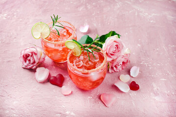 Fototapeta na wymiar Classic pink daiquiri with rum, orange liqueur and lime juice served as a Valentine's Day gift in two glasses and decorated with roses and hearts