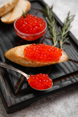 Tasty bruschetta with red caviar on grunge background