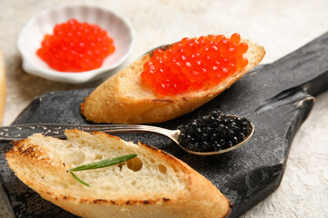 Tasty bruschettas with red and black caviar on grunge background