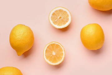 Composition with cut and whole fresh lemon on pink background