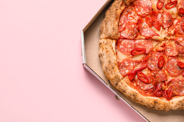 Cardboard box with delicious pepperoni pizza on pink background