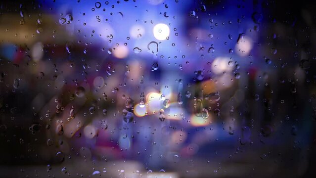 Rain running down a window against bokeh background