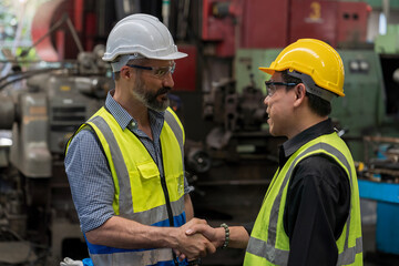 Engineer people Happy to be successful partnership team. Smiling Engineer shaking hands. Metal Machine.
