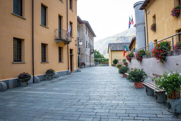 Fototapeta na wymiar a street in Bard village decorated with flower pots, Aosta Valley, Italy