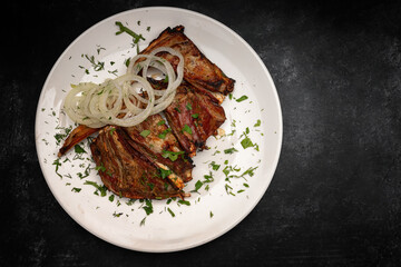Mouth-Watering Pork Ribs with Onion Rings and Parsley Garnish