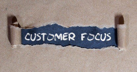torn paper and black board lettering customer focus