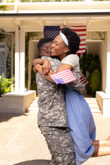 African american soldier husband embracing excited wife after returning home from army, copy space