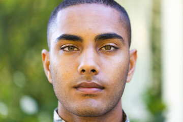 Portrait of biracial male soldier wearing military uniform looking at camera