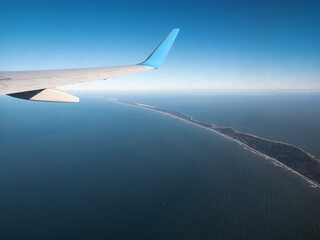 Fototapeta premium Airplane wing. Aerial View from plane window on Curonian Spit with Baltic sea shore