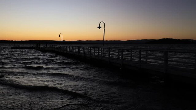 Lake Macquarie sunset at Murrays beach jetty with fishers as 4k timelapse.
