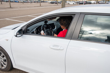 African Businesswoman in red coat using disinfectant wet tissue wipe on steering