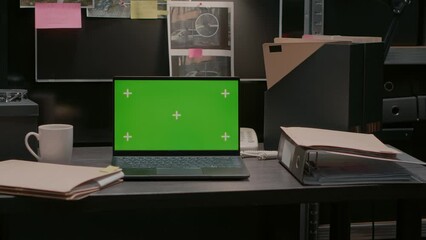 Greenscreen display on portable laptop in incident room, isolated chroma key template. Wireless computer placed on desk showing blank copyspace mockup screen, evidence board map.