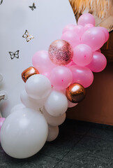 Multi-colored balloons hang on the background of the wall at the girl's children's birthday party. Closeup photography, holiday, photo zone, copy space.
