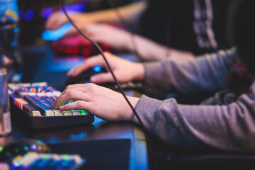 Cyber sport e-sports tournament, team of professional gamers, gamer's hands on mouse and keyboard, pushing button, gamers playing in competitive moba, strategy fps game in a cyber games arena club