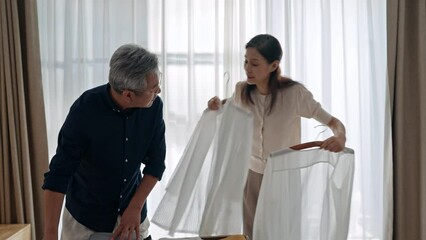 Happy mature couple packing suitcase for vacation,4K - Powered by Adobe