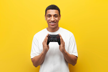 joyful guy african american gamer holds joystick for video games, man shows and advertises gaming device