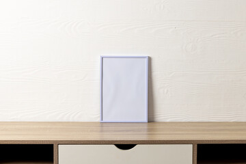 White empty frame with copy space on table against white wall