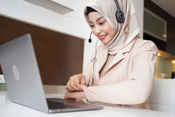Asian Muslim customer service agent or call center working at the office.