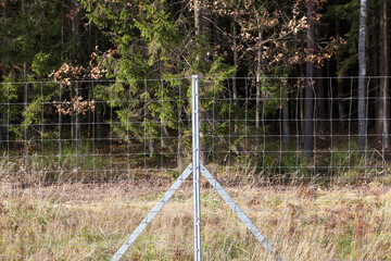 metal fencing in the forest to protect the territory from wild animals