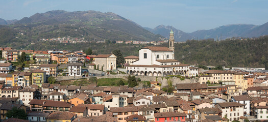 Obraz premium Overview of the town of Vertova (Province of Bergamo, Lombardy, Italy) with the parish church of Santa Maria Assunta rebuilt in the 18th century to a design by Giovanni Battista Quadri. April 2023.