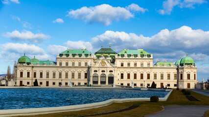 Majestic baroque architecture of Belvedere palace near great water basin in upper parterre of historic building complex in Vienna on sunny winter day, Austria